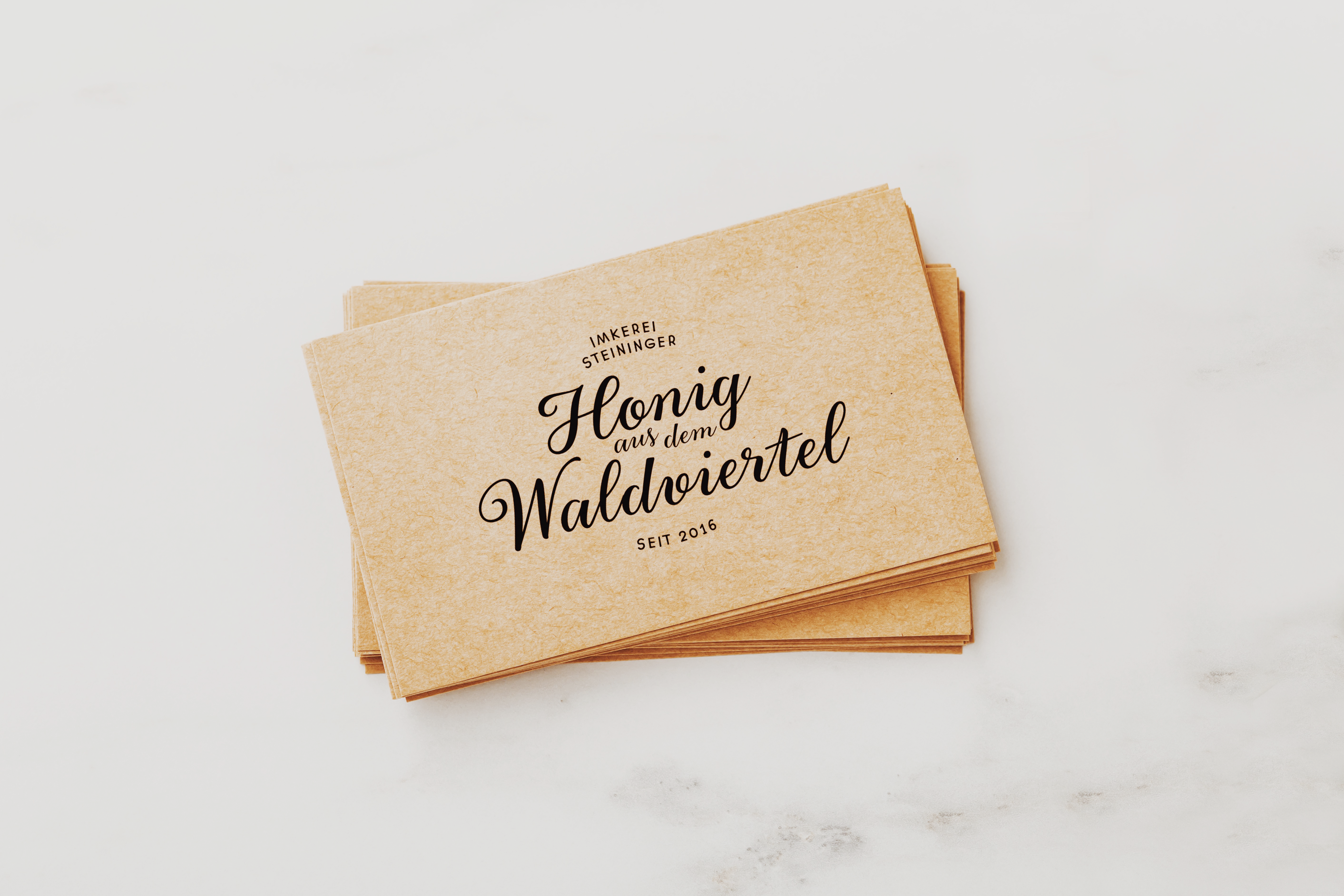 Brand Design für eine Imkerei im Waldviertel. Hier sieht man Visitenkarten mit dem Logo "Honig aus dem Waldviertel" auf braunem Recyclingkarton.